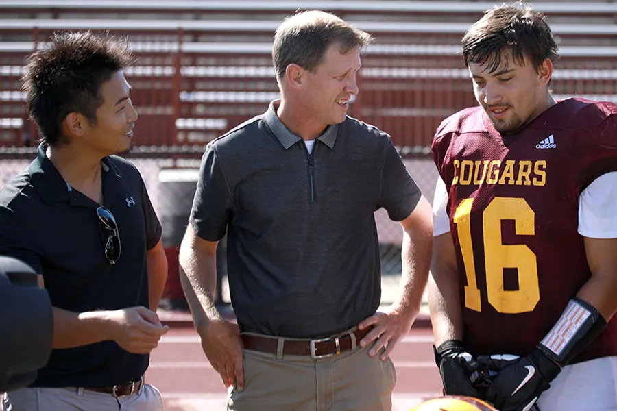 Kei Kawada stands with a Bloomington North High School football player