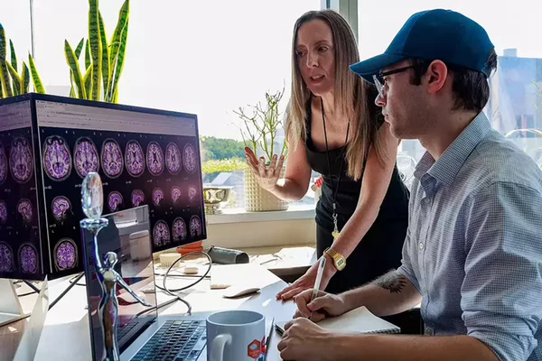 Amanda Mejia and statistics master's student Garrett Collier review the results of an advanced functional MRI processing and quality control pipeline.