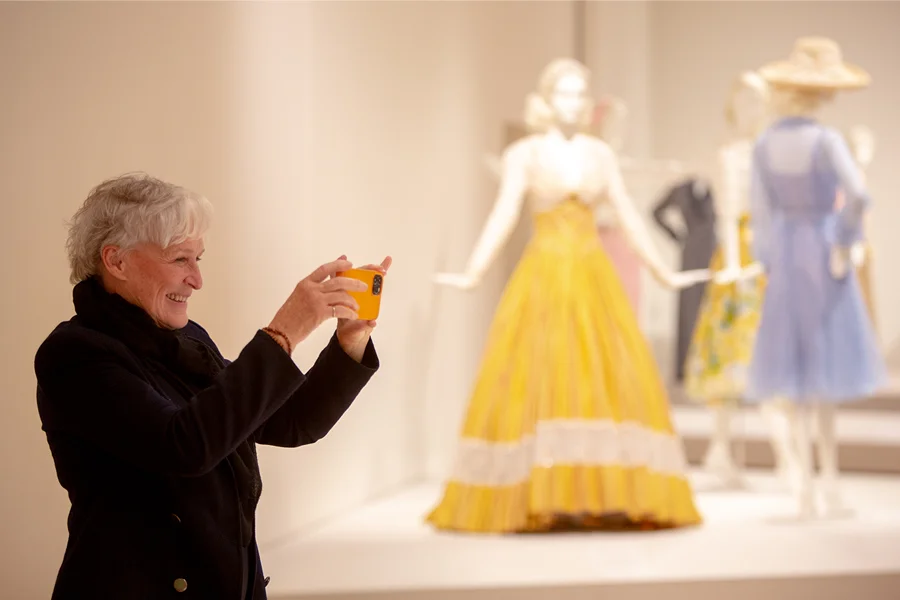 Glenn Close photographs a dress at an exhibition at IU Bloomington in 2021, which showcased her costume collection.