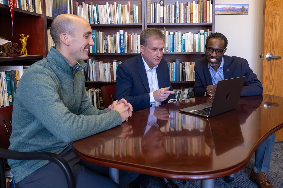 Andrew Whitehead, director of the Association of Religion Data Archives, Philip Goff, executive director of the Center for the Study of Religion and American Culture, and Joseph L. Tucker Edmonds, associate director of the center, seated in front of shelves of books.