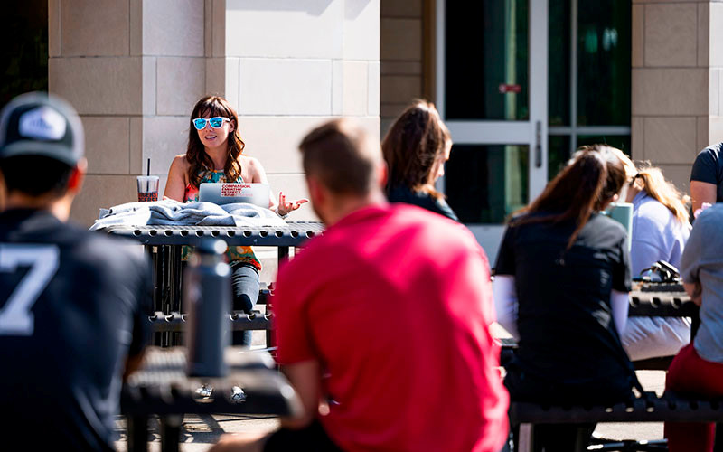 IU South Bend students sit outside at tables.