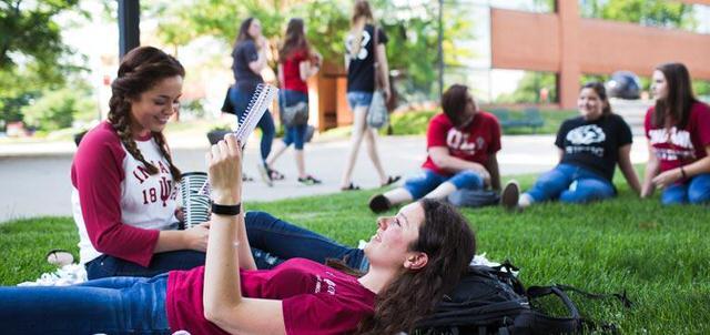 iu columbus students sit on lawn wide